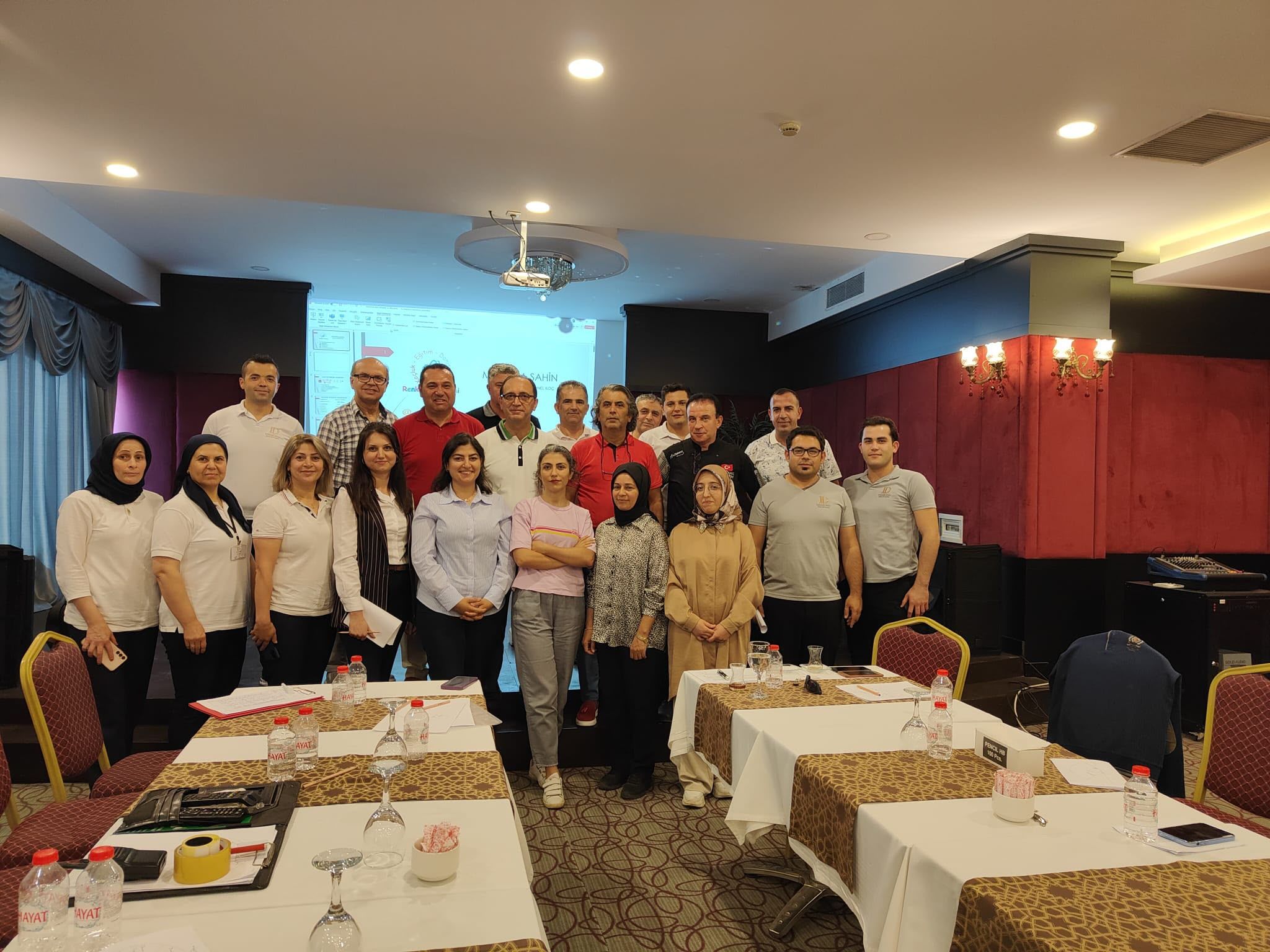 Bir eğitim salonunda bir araya gelen katılımcı grubu