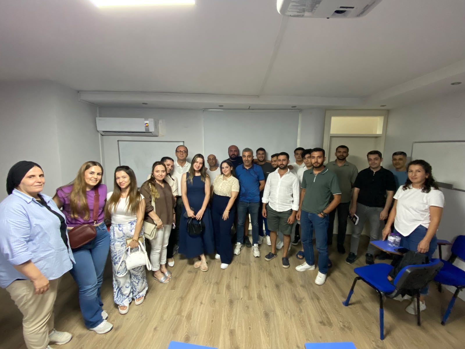 Sunum salonunda toplu fotoğraf veren eğitim katılımcıları