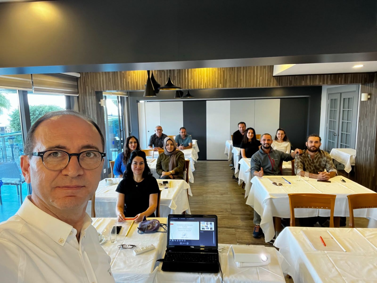 Bir eğitim salonunda eğitmen ve katılımcıların birlikte olduğu fotoğraf