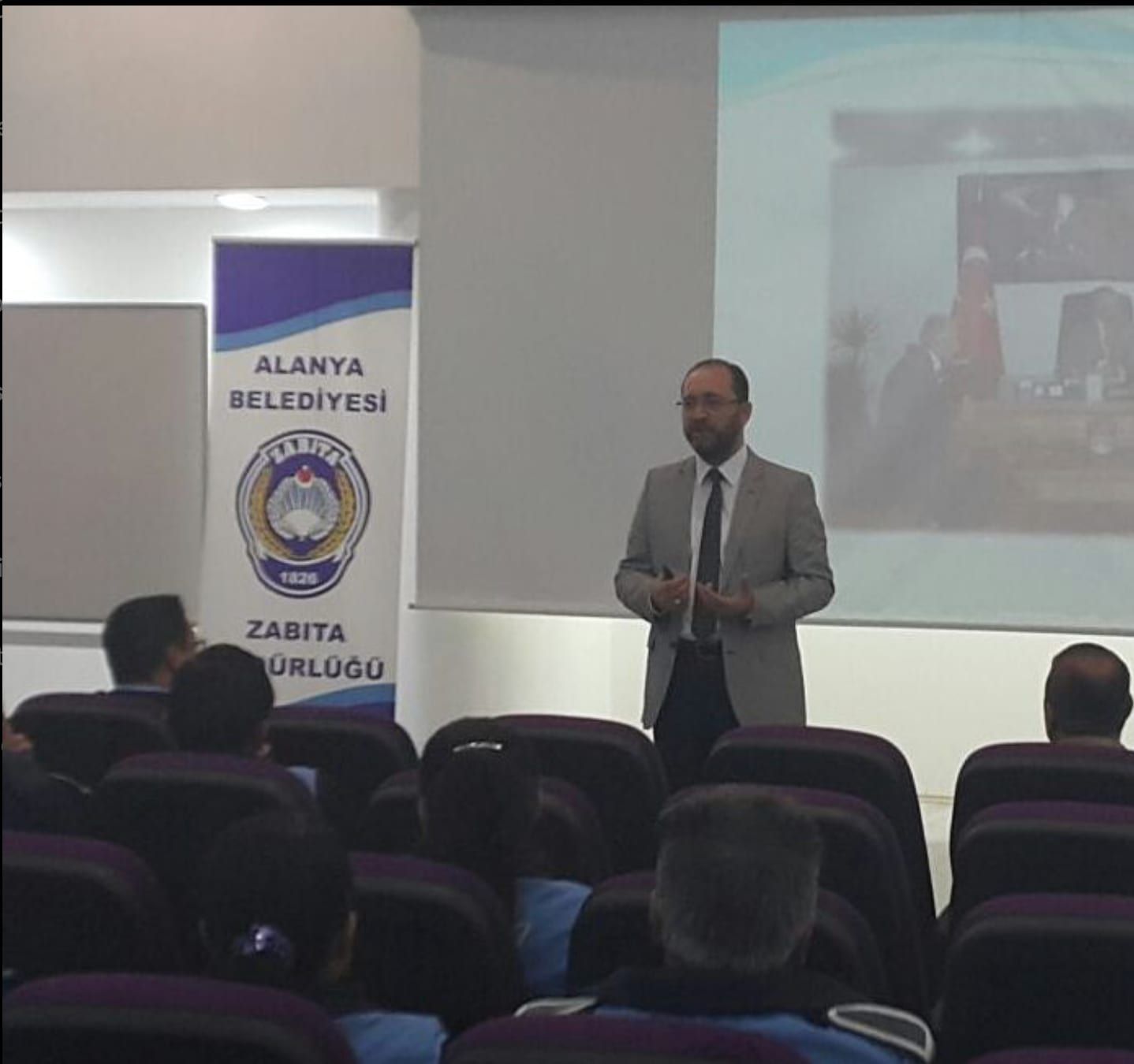 Konferans salonunda katılımcılara sunum yapan eğitmen